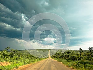 Traveling on road in africa with dark clouds on the horizon