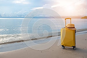 Traveling suitcase with hat on the beach, traveling and relaxing time concept