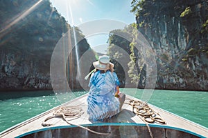 Traveling in Thailand. Asian woman sitting on the head of  wooden longtail boat travel on the sea go to the amazing island