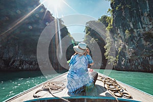 Traveling in Thailand. Asian woman sitting on the head of  wooden longtail boat travel on the sea go to the amazing island