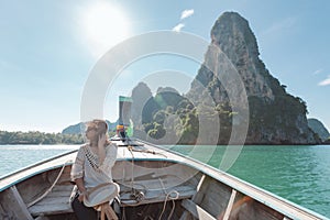 Traveling in Thailand. Asian woman sitting in the wooden longtail boat travel on the sea go to the amazing island