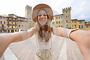 Traveling in Tuscany. Smiling tourist girl in Piazza Grande square in the historic town of Arezzo, Tuscany, Italy photo