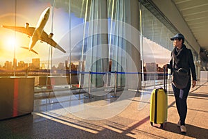 Traveling woman and luggage walking in airport terminal and air