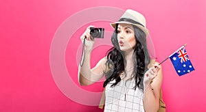 Traveling young woman holding a camera with Austlarian flag