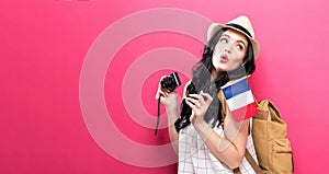 Traveling young woman holding a camera with Italian flag