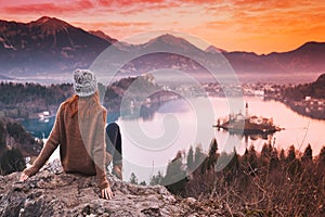 Traveling young woman looking on sunset on Bled Lake, Slovenia,