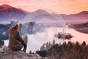 Traveling young woman looking on sunset on Bled Lake, Slovenia,