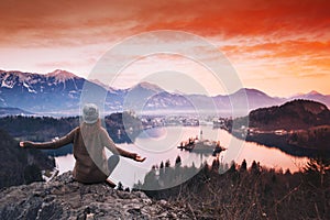 Traveling young woman looking on sunset on Bled Lake, Slovenia,