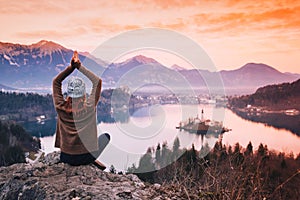 Traveling young woman looking on sunset on Bled Lake, Slovenia,