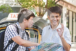 Traveller asking directions from taxi driver to get him to landmark in bangkok thailand