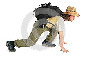 Traveller with backpack in straw hat on all fours