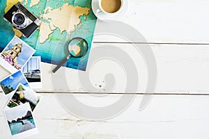 Traveller desk with folded paper map of world and photos