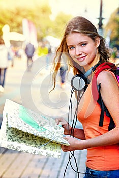 Traveller girl with backpack looking for way tourist paper map
