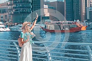 Traveller girl with a map is waiting for her cruise ship at the Marina port in Dubai