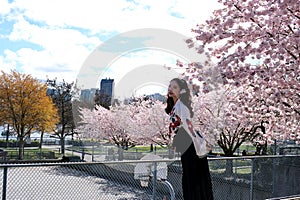 traveller girl walk beautiful young Oriental girl waving her head developing her hair against the background of cherry