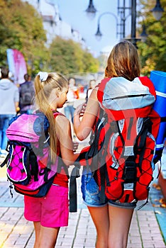 Traveller girls with backpack search way by tourist paper map