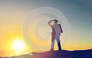 Traveller looking far away over sunrise