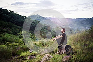 Traveller man with backpack sitting on rock at outdoor,Meditations to calm your mind and body