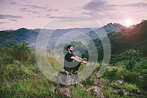 Traveller man with backpack sitting on rock at outdoor,Meditations to calm your mind and body