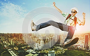 Traveller man jumping floating over modern city skyscraper