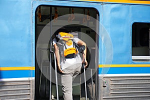 Traveller travel alone are getting on the train with backpack,Transportation concept