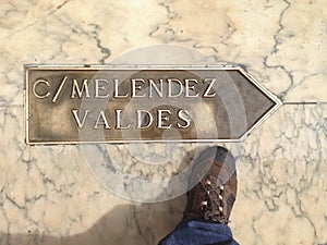 Traveller walking over street direction arrow at Badajoz Old Tow