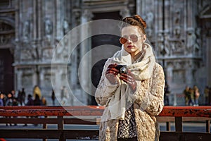 Traveller woman in front of Cathedral viewing photos on camera