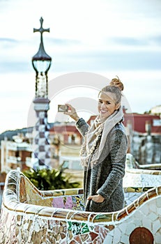 Traveller woman at Guell Park taking photo with digital camera