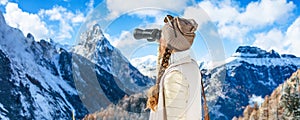 Traveller woman looking into the distance through binoculars