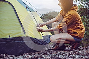 Traveller young asian girl putting up a tent in nature,Enjoying camping concept