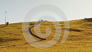 Travellers hiking on trail road along mountain range in Swiss Alps in autumn