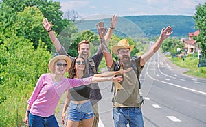 Travellers try to stop car. Friends hitchhikers travelling summer sunny day. Company friends travelers hitchhiking at