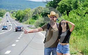 Travellers try to stop car. Hitchhiking is one of cheapest ways of traveling. Couple hitchhikers travelling summer sunny photo