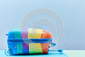 Travelling background. Summer vacation. Travelling abroad. Summer time. Bright colourful suitcase on blue, copy space