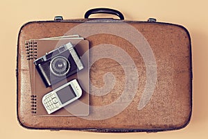 Travelling background. Traveler set. Travel blogging. Top view of suitcase, camera and cellphone. Vintage luggage case