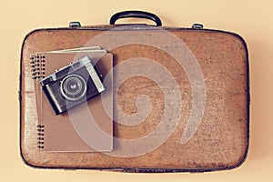 Travelling background. Vintage travel. Blogging. Top view of retro leather suitcase with notepad and camera, copy space