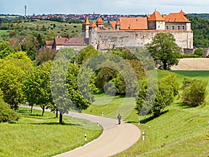 Travelling by bike in green summer season nature towards a medieval castle in Germany