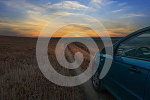 Travelling by car. Country field road at sunset. Countryside landscape