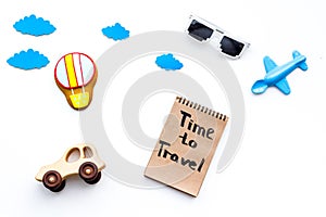 Travelling with child concept. Airplan and car toy, air balloon cookie. Time to travel hand lettering in notebook on