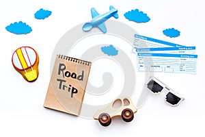 Travelling with child concept. Airplan toy, air balloon cookie, airplan tickets. Road trip hand lettering in notebook on