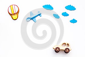 Travelling with child concept. Car and airplan toy, air balloon cookie on white background top view copy space