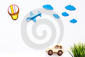 Travelling with child concept. Car and airplan toy, air balloon cookie on white background top view copy space