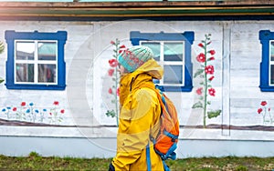 Travelling man in front of traditional wooden house