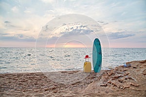 Travelling set, surfboard and suitcase. Sunset over sea, sandy coastline. Summer vacation and surfing idea. Copy space