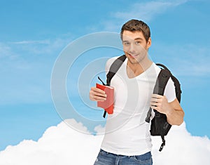 Travelling student with backpack and book