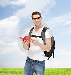 Travelling student with backpack and book