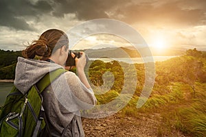 Travelling woman photographer with backpack making an inspiring