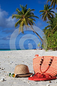 Traw hat, bag, sun glasses and flip flops on the beach