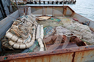 Trawl, pelagic boards, fishing net lies on the fishery deck of a small fishing seiner