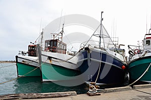 Trawler Fishing Boats Secured To Pier In Harbor